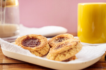 Dress neutral some homemade butter cookies with jam accompanied by a cup of coffee. Homemade and natural food concept.