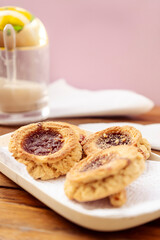 High view some homemade butter cookies with jam, in the background you can see a sugar bowl out of focus. Homemade and natural food concept. Vertical orientation. Copy space.