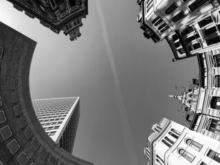 Looking up black and white shot of a clear sky with a plane trail passing through the middle...