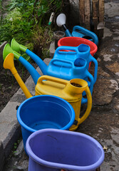 watering cans of different colors for watering flower beds and beds