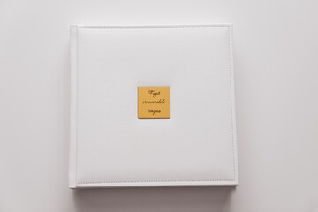 white book in leather binding with gold metal insert with inscription in latin