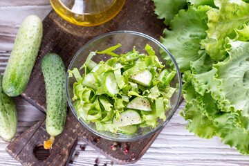 Detox salad from green vegetables (cabbage, cucumber, green onion and parsley) on a plate. Top view.
