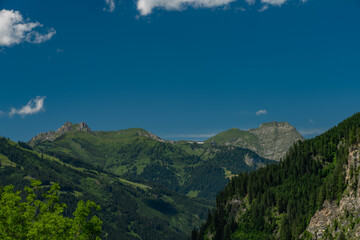 Summer valley with Grossarler Ache small river and blue cloudy sky