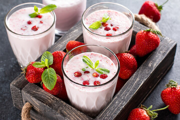 Fresh healthy strawberry smoothie on wooden background