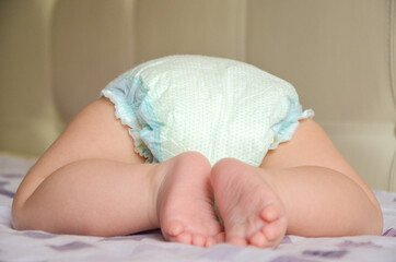 Newborn in a diaper back view. Close-up. Copy space. - obrazy, fototapety, plakaty