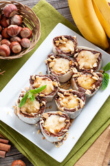 Delicious roll with banana slices on table. Banana roll with chocolate dessert