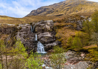 Three waterfalls flow downhill at Glencoe, Scotland on a summers day