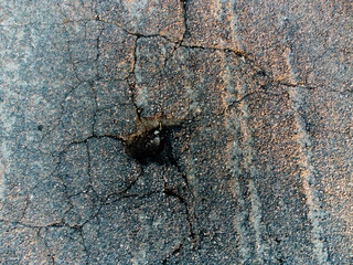 Pit on the asphalt. Spoiled road.