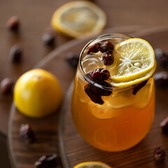 Refreshing healthy drink on wooden table. Orange citrus beverage. Glass of lemonade. Close-up shot. Soft focus.