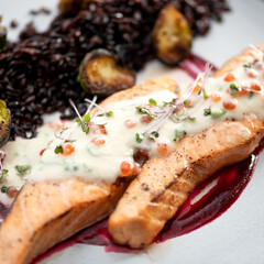 Fried salmon fillet with microgreens, sauce and red caviar. Seafood concept. Close-up shot. Square format. Soft focus.