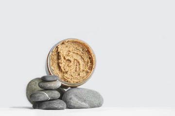 Coffee scrub on texture stone and copy space. Сosmetics, skincare products on natural podium. Top view.