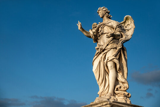 Beautiful detail of an Angel from the Bernini school, Castel Sant'Angelo, Vatican, from the Ponte degli Angeli over the Tiber, with a clear blue sky after a thunderstorm, Vatican, Rome, Italy.