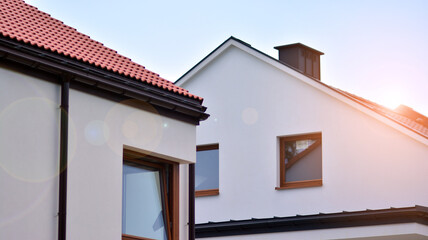 New single family house in a new development area.  Residential home with modern facade. Rays of...