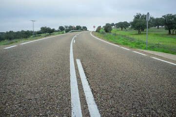 Fototapeta na wymiar Spanish dehesa countryside curvy road with change of slope