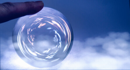 Crystal ball with resting finger and clouds