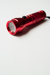 Red bright flashlight with led bulbs on a white background with copy space 