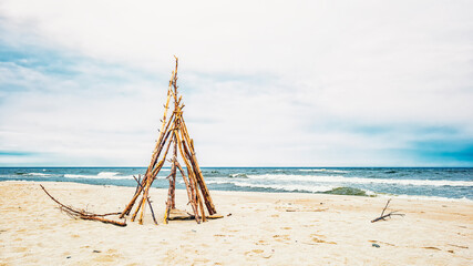 The frame of a wooden tent on a sandy seashore