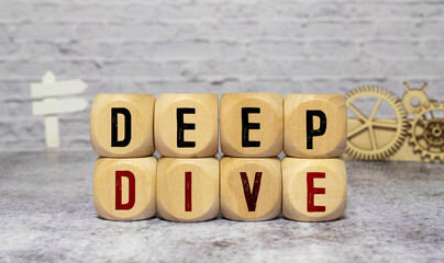 Modern business buzzword - deep dive. Top view on wooden table with blocks.