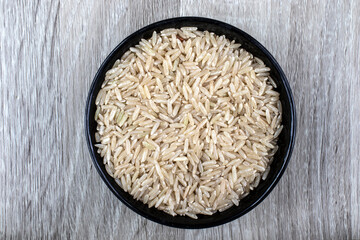 Top view of integral rice on glass bowl isolated on wooden table in Brazil