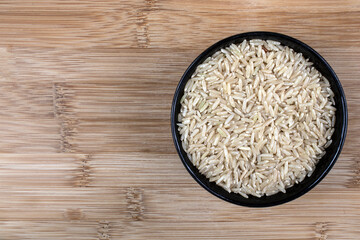 Top view of integral rice on glass bowl isolated on wooden table in Brazil