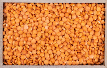 Top view of red lentils in a rectangular wooden box