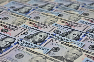 Close-up de muitas notas juntas de cinquenta e cem dólares colocadas em diagonal  	
