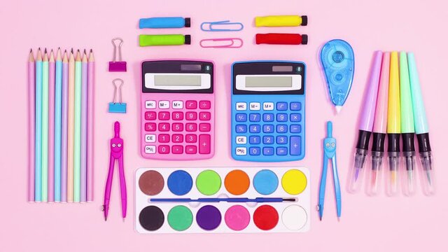 Vibrant school accessories make creative pastel layout on pastel pink theme. Stop motion