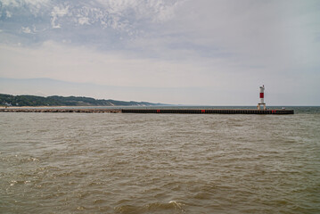 Holland, MI, USA - June 8, 2008: Long pier with red-white light beacon separates Macatawa lake from...