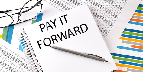 Notebook with text PAY IT FORWARD . Diagram and white background,Business concept