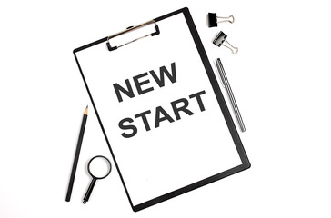 On a white background magnifier, a pen and a sheet of paper with the text NEW START , . Business concept
