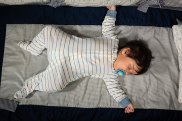 top view of a hispanic baby sleeping in his crib