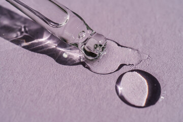 A cosmetic product flows out of a pipette with bubbles.