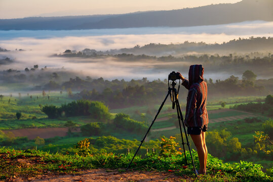 Traveller Takes Photos Of Dreamy Majestic Landscape, Sunset At Horizon And Watching Into Colorful Mist And Fog In Morning Valley.Travel Concept