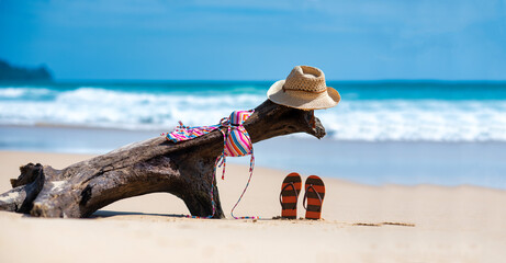 Swimming suit , hat, and flip flops on a tropical beach
