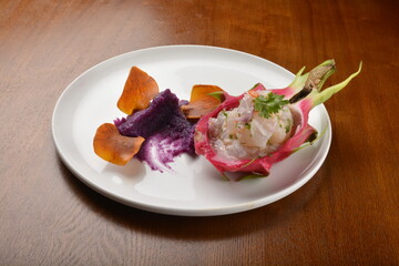 cold pink dragon fruit salad with root paste appetiser on wood table fine dining western menu
