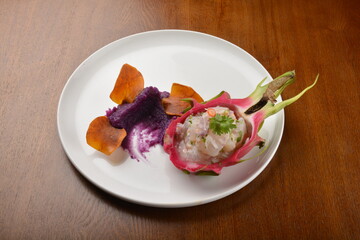 cold pink dragon fruit salad with root paste appetiser on wood table fine dining western menu