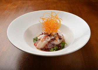 cold dish octopus sashimi salad with green vegetables and carrot appetiser on wood table fine dining western menu
