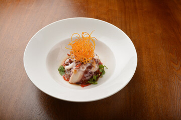 cold dish octopus sashimi salad with green vegetables and carrot appetiser on wood table fine dining western menu