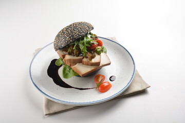 vegetarian burger with tofu bean curd, mushroom and vegetables in chef special sauce charcoal bun in white background western vegan halal menu