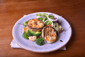 vegetarian grilled big fresh mushroom with bake cheese porbettolo and broccoli vegetables wood table western vegetarian menu