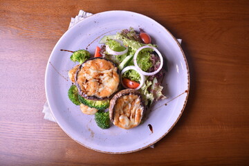 Fototapeta na wymiar vegetarian grilled big fresh mushroom with bake cheese porbettolo and broccoli vegetables wood table western vegetarian menu