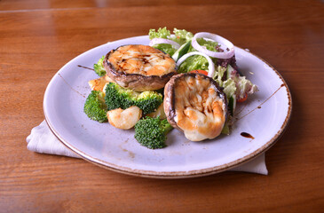 vegetarian grilled big fresh mushroom with bake cheese porbettolo and broccoli vegetables wood table western vegetarian menu