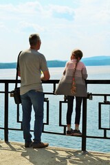 Father and little daughter admire the lake from the observation deck 