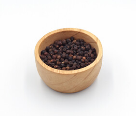black pepper in a wooden bowl isolated on white background