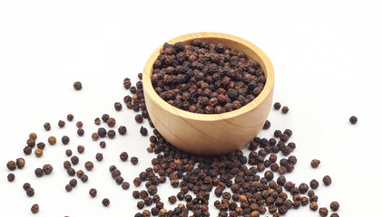 black pepper in a wooden bowl isolated on white background