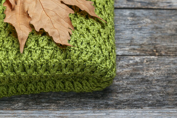 Knitted shawl with leaves on an old wooden table