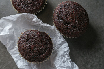 Delicious and fresh chocolate muffins on a gray ceramic table.