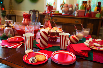 Detail of dining room table decorated for festive Christmas party with sweets and large punch bowl 