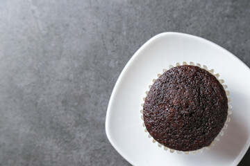 Delicious and fresh chocolate muffins on a gray ceramic table.