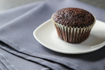 Delicious and fresh chocolate muffins on a gray ceramic table.